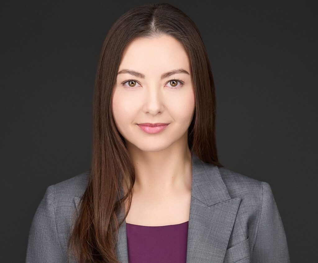 Professional headshot of a woman with long brown hair in business attire.