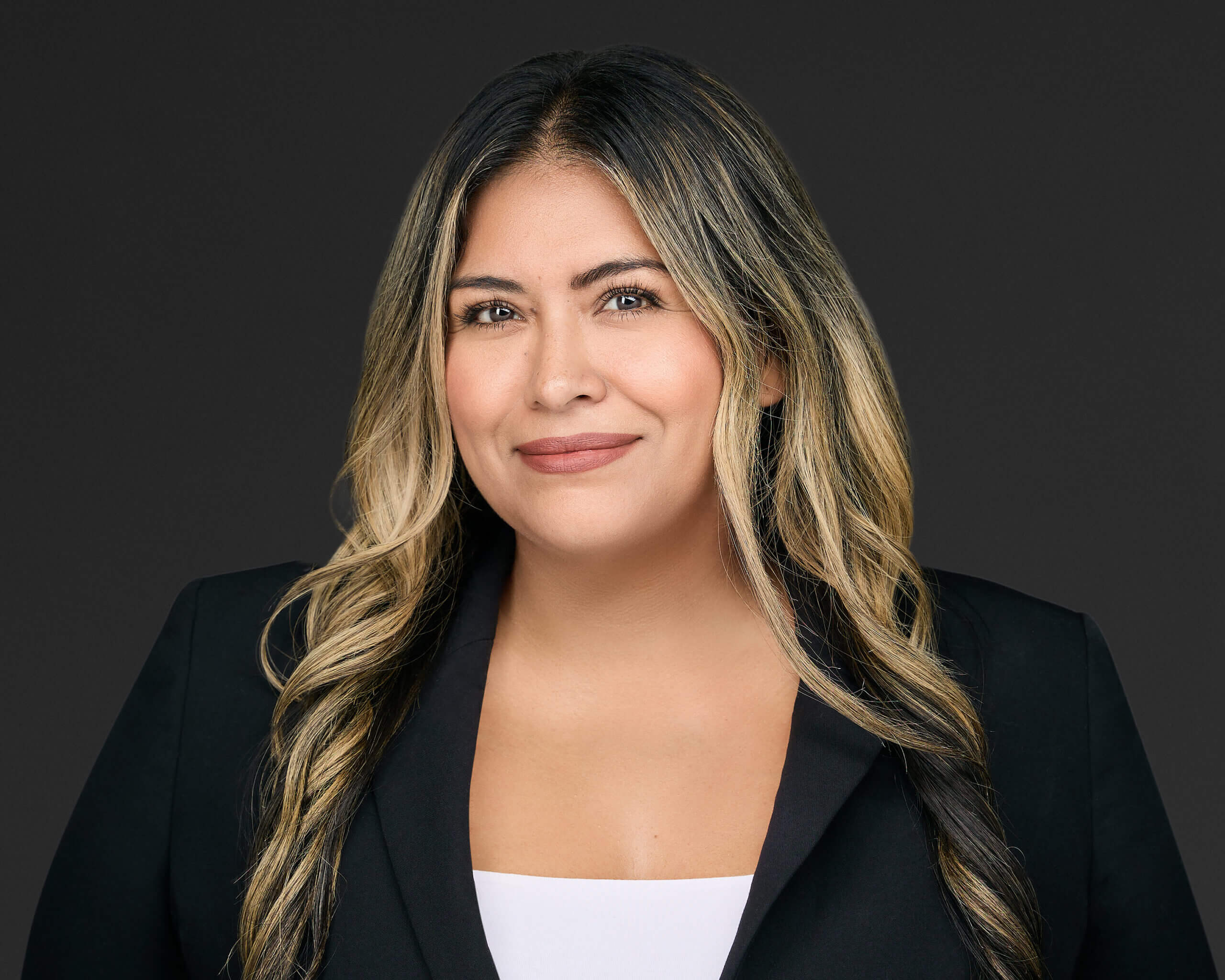 Professional woman smiling with long blonde hair and black blazer.