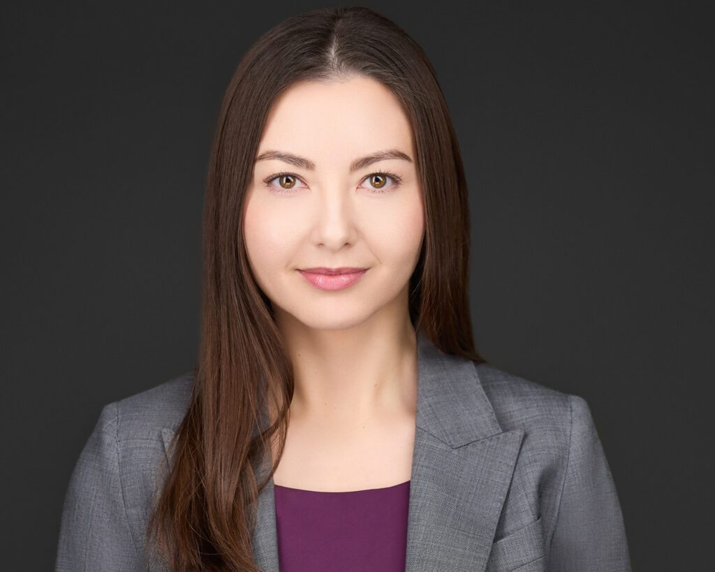 Professional headshot of Susanna F. Wiseman, Esq., partner at Madison Law, in a grey jacket and purple blouse, smiling confidently.